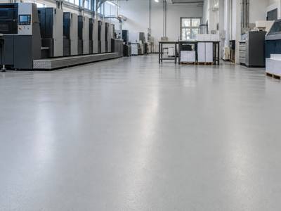 Industrial floor coating beneath a large press in an Oxford County printing plant
