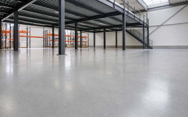 Painted structural steel mezzanine standing over a coated warehouse floor in Woodstock
